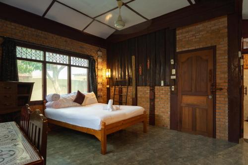a bedroom with a bed and a window and a door at Boutique House Nipha in Chiang Mai