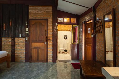 a room with a door and a bathroom with a toilet at Boutique House Nipha in Chiang Mai