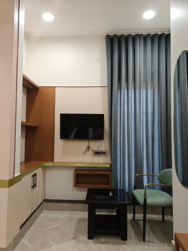 a living room with a television and a table and chairs at Hotel ROYAL DC in Alīgarh