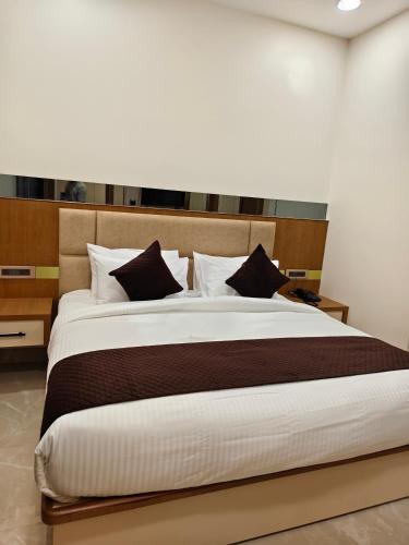 a bedroom with a large bed with brown and white pillows at Hotel ROYAL DC in Alīgarh