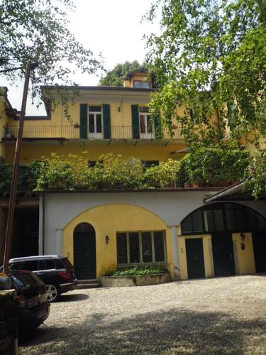 a yellow house with a car parked in front of it at Il Platano in Como