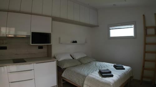 a small bedroom with a bed and a kitchen at Tiny House Krumlov, Terrace, Parking in Český Krumlov