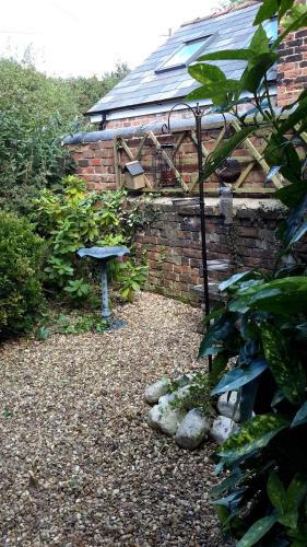 a garden with a brick building and a bird bath at The School House in Warrington
