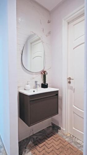 a bathroom with a sink and a mirror at chez moi sfax ville in Sfax