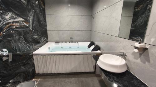a bathroom with a tub and a toilet and a sink at Mojo stay hotel in Ahmedabad