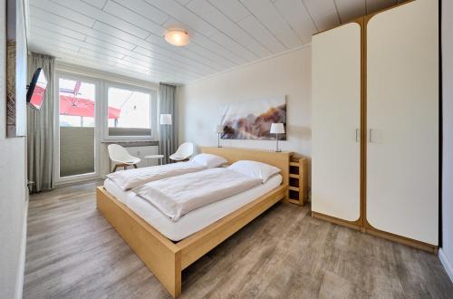 a bedroom with a bed and a table and chairs at Haus Schildt, FeWo 8 in Duhnen