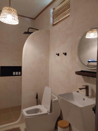 a bathroom with a white toilet and a sink at Nomad Beach House, Koh Lanta in Ko Lanta