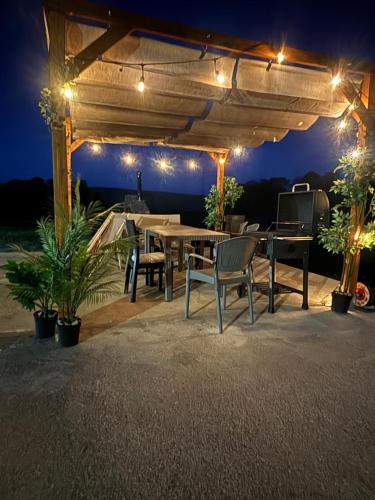 a patio with a table and chairs and lights at Osada Narost 37 in Chojna