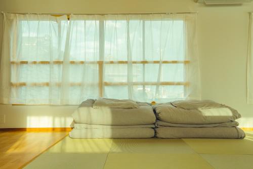 a bed sitting on the floor in front of a window at 浬-kairi-1852 in Choshi