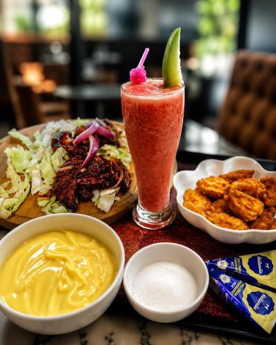 a table with a plate of food and a drink at Star Haven Hotel and suites in Badore