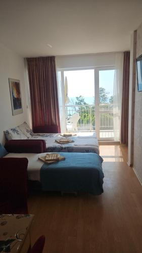 a hotel room with two beds and a large window at Sunny House Byala in Byala