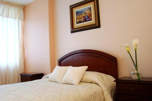 a bedroom with a bed and a picture on the wall at Hotel Torre Norte in Trujillo