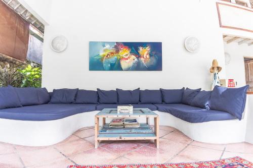 a living room with a blue couch and a table at Villa Raquel by Betterplace in Seminyak