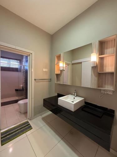 a bathroom with a sink and a toilet at Seri Botani Private Pool Villa 5BR in Ipoh