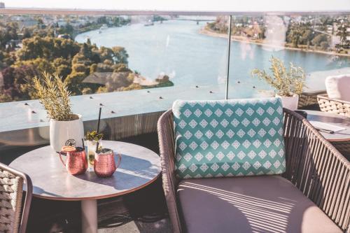 a table and chairs with a view of the water at Radisson Blu Hotel, Bonn in Bonn
