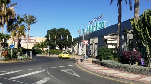 a yellow car driving down a street in front of a building at Villa con Piscina ,Vista Mar y campo de golf in Caleta De Fuste