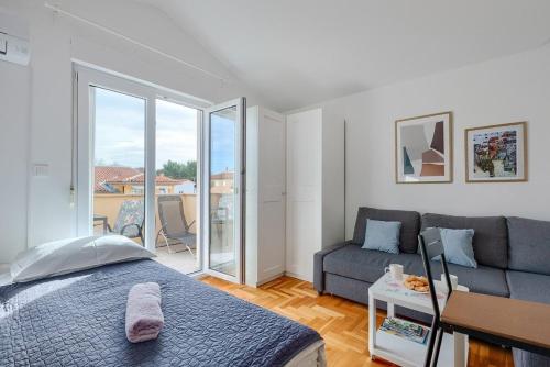 a bedroom with a bed and a couch at Apartment Vallera in Medulin