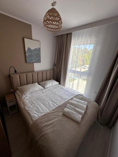 a bedroom with a large bed with a window at Szum Bałtyku in Jastrzębia Góra