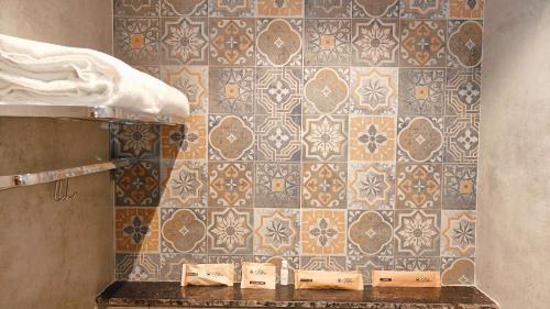 a bathroom with a tile wall and a sink at Bliss Giriya By Bergamont in Tiruvannāmalai