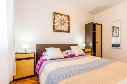 a bedroom with a large bed with purple and white sheets at Apartments Racchi in Banjole