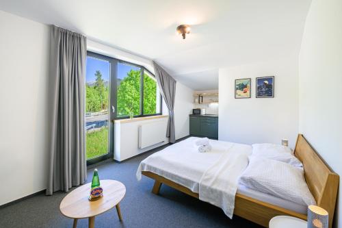 a bedroom with a bed and a large window at Vila Matliare in Tatranská Lomnica