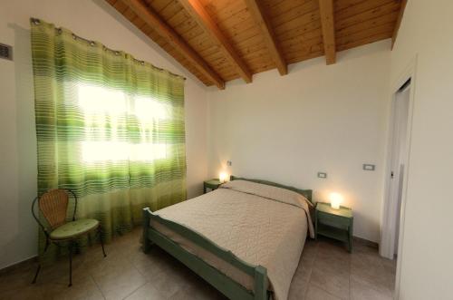 a bedroom with a bed and a window with green curtains at B&B Al Tardino in Sogliano al Rubicone