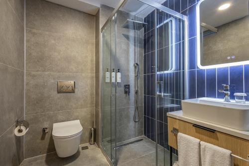 a bathroom with a shower and a toilet and a sink at The Komana Dardanelles in Hamidiye