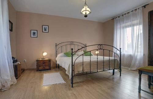 a bedroom with a metal bed and a window at Villa Dea in Svetvinčenat