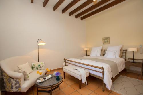 a bedroom with a large bed and a couch at Casa Font i Roig in Maria de la Salut