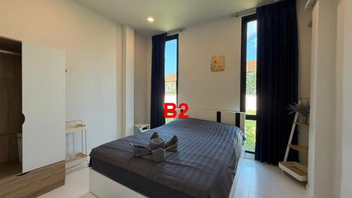 a bedroom with a bed with a bow pillow on it at Pool Villa Maephim 34, by Somjai in Ban Tha Fat