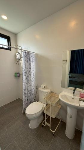 a white bathroom with a toilet and a sink at Pool Villa Maephim 34, by Somjai in Ban Tha Fat