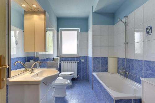 a blue and white bathroom with a toilet and a sink at Villa Semy in Pazin