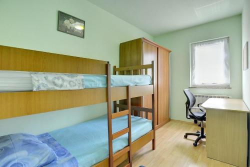 two bunk beds in a room with a desk and a chair at Villa Semy in Pazin