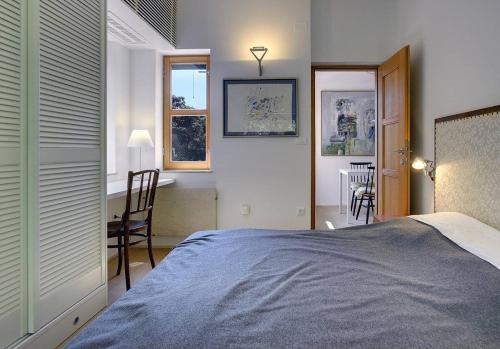 a bedroom with a bed and a desk and windows at Villa Mala Villa in Krnica