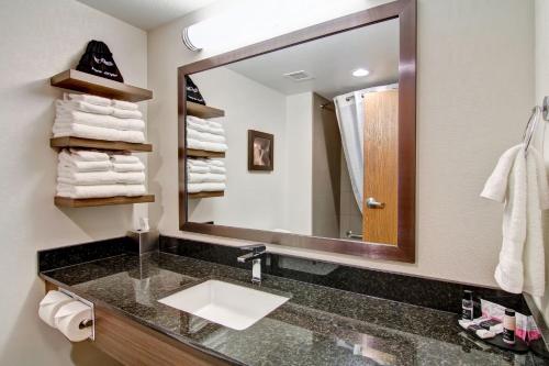 a bathroom with a sink and a large mirror at Canalta Kindersley in Kindersley