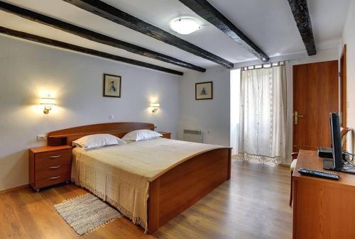 a bedroom with a large bed and a television at Villa Lucy in Barban
