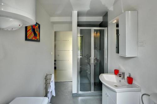 a white bathroom with a shower and a sink at Villa BR in Ližnjan