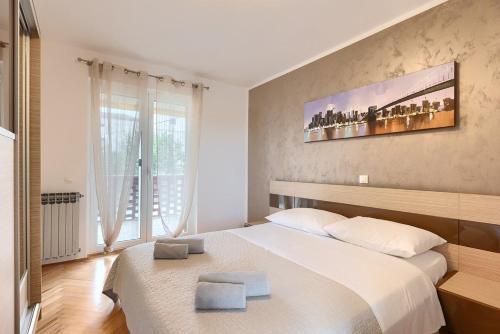 a bedroom with a large bed with two towels on it at House Casa Alberta in Rovinjsko Selo