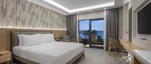 a bedroom with a bed and a view of the ocean at The Komana Dardanelles in Hamidiye