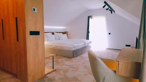 a bedroom with a bed and a sliding glass door at Marisel Escape Chalet in Mărişel
