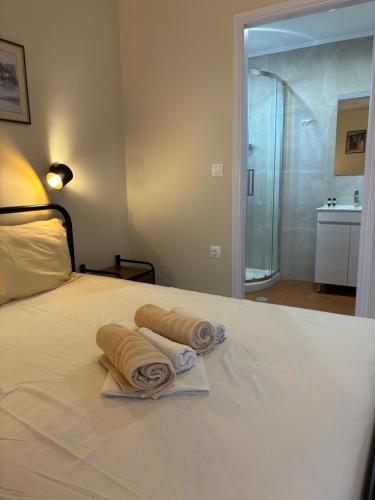 a bedroom with a bed with towels on it at Polyxenis Rooms in Lygia