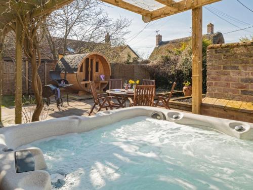 a hot tub in a backyard with a table and chairs at Lavender Cottage - Ukc9687 in Thorndon