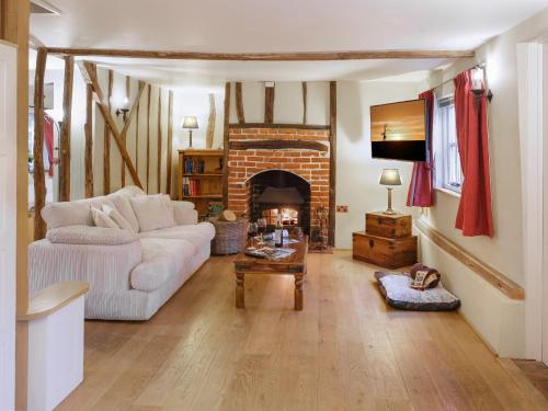 a living room with a white couch and a fireplace at Lavender Cottage - Ukc9687 in Thorndon