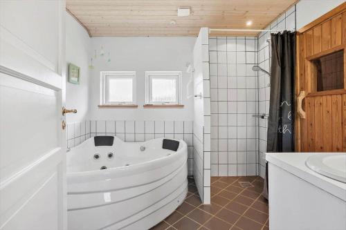 a white bathroom with a tub and a sink at FY130-Middelfart-Stjernevej-117 in Middelfart
