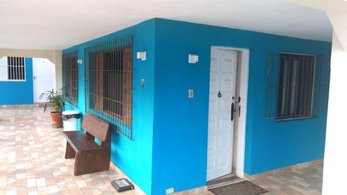 a blue wall with a bench next to a door at Hotel Pousada Vivendas do Sol e Mar in Caraguatatuba
