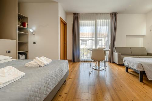 a bedroom with two beds and a table and a couch at Hotel Rubicone in Savignano sul Rubicone