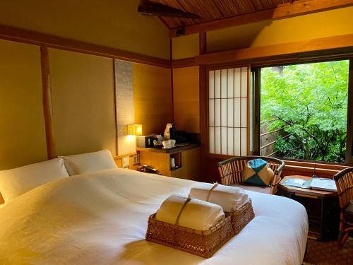 a bedroom with a large white bed and a window at Yasaka Yutone Kyokoyado in Kyoto