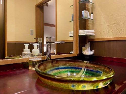 a bathroom sink with a glass bowl on a counter at Yasaka Yutone Kyokoyado in Kyoto