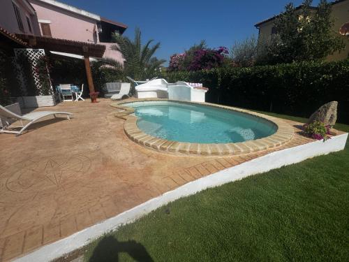 a swimming pool in a yard with a patio at Casa Vacanza Li Menduli San Teodoro in San Teodoro