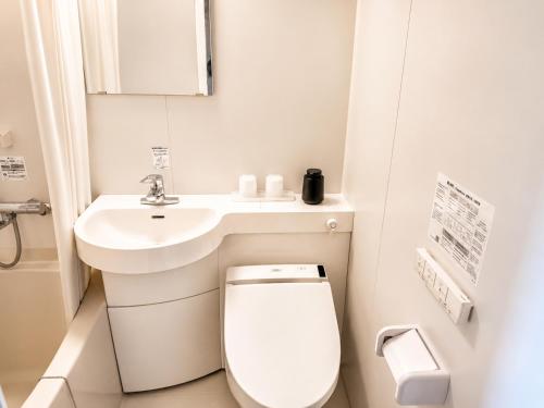 a white bathroom with a toilet and a sink at 江田島BASE in Okimi in Etajima